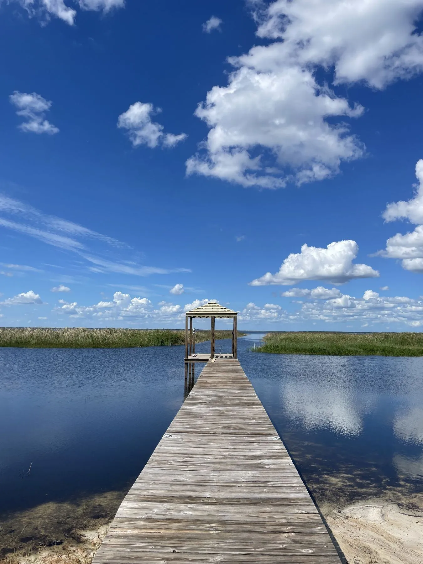 Wood pier with a covered platform at the end, over the water