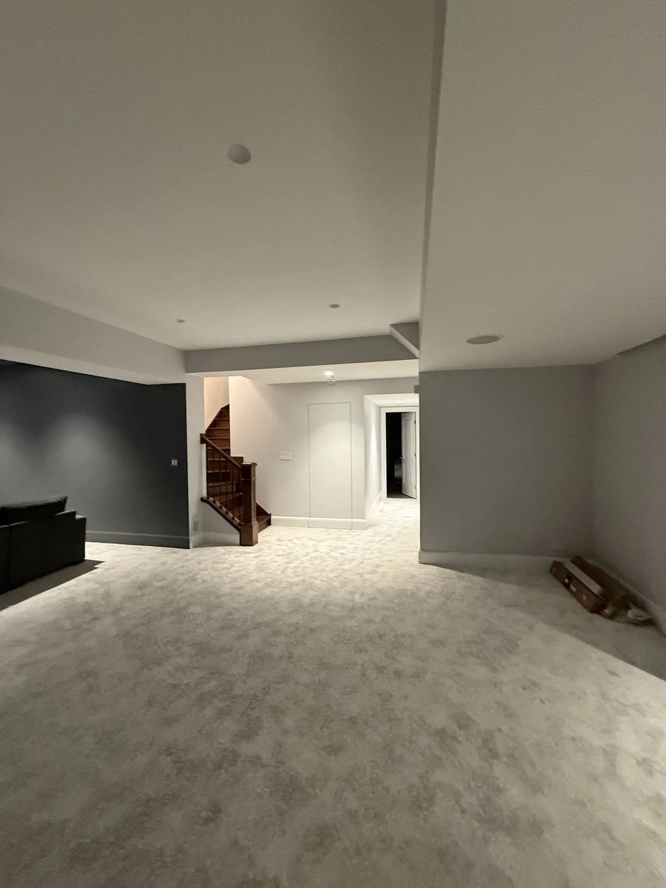 Finished basement with carpet and a stair