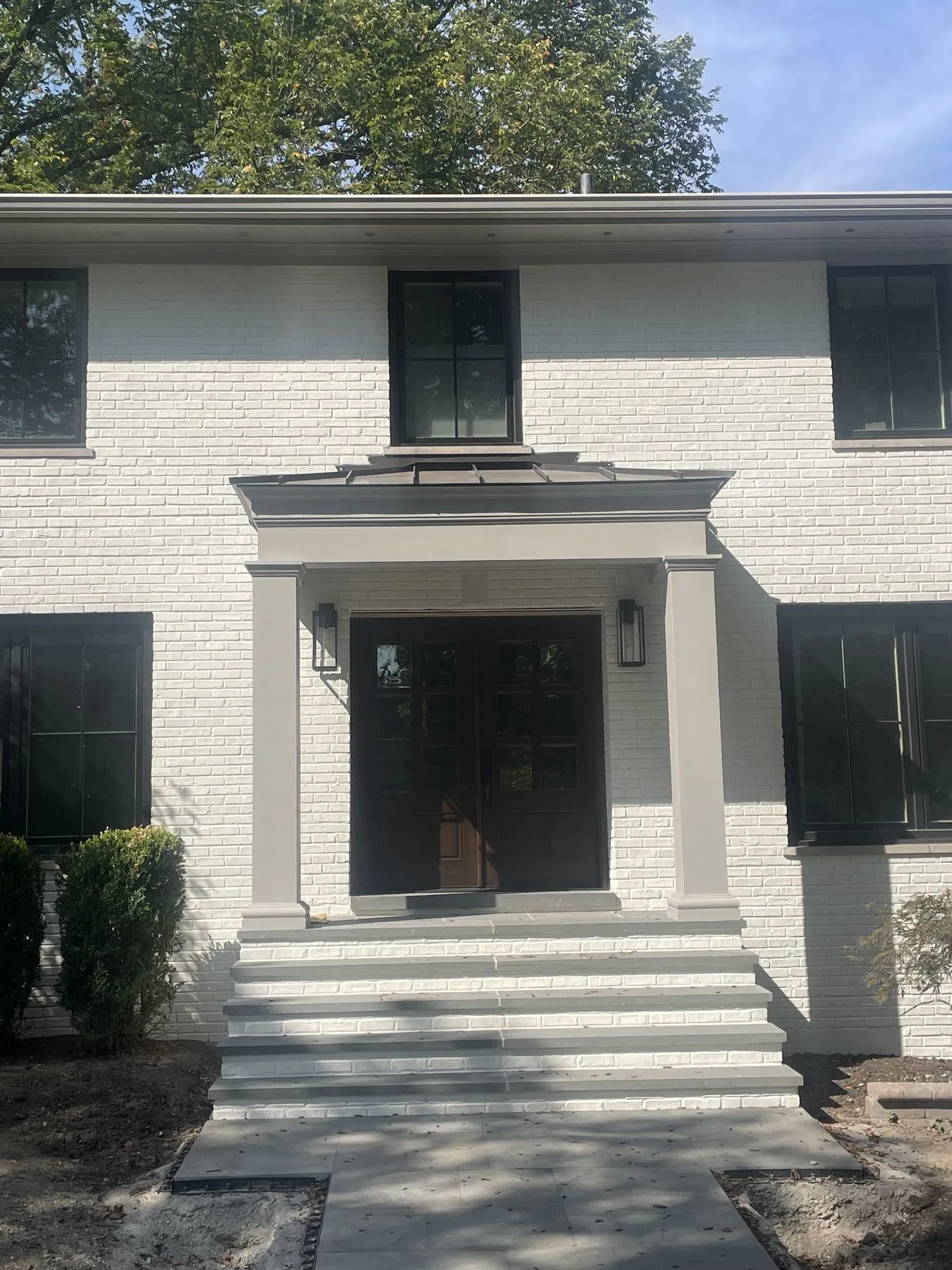Covered portico with columns over a pair of front doors