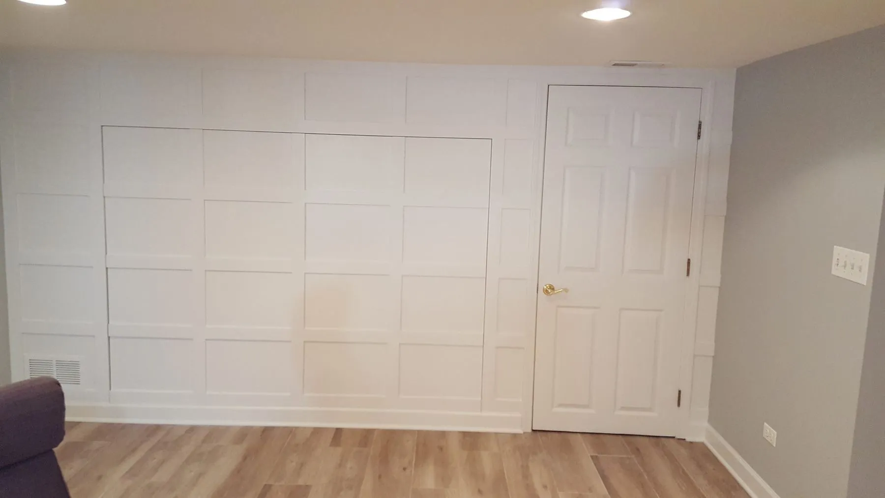 Paneled wall and door in the finished room