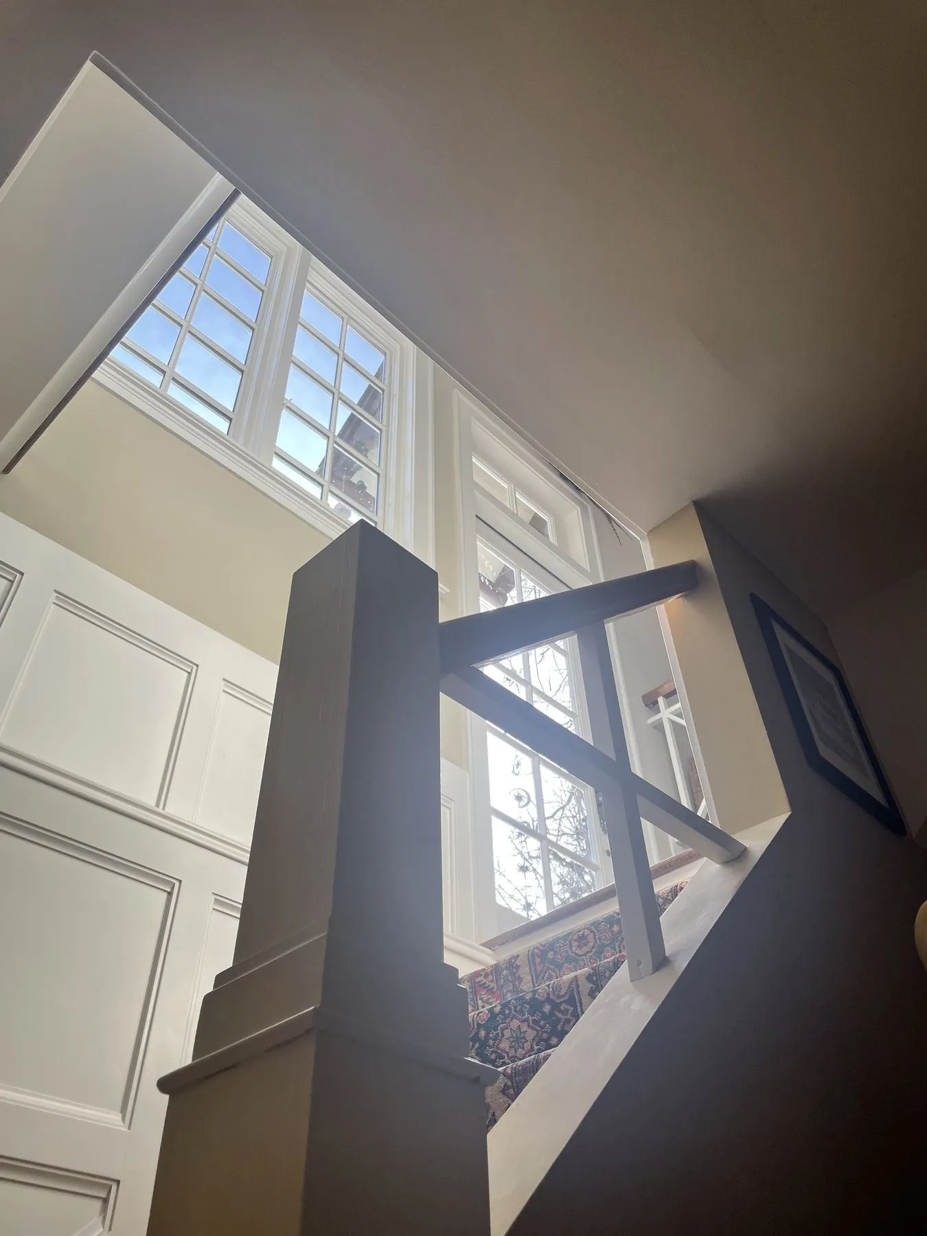 Newel post and railing below a row of windows