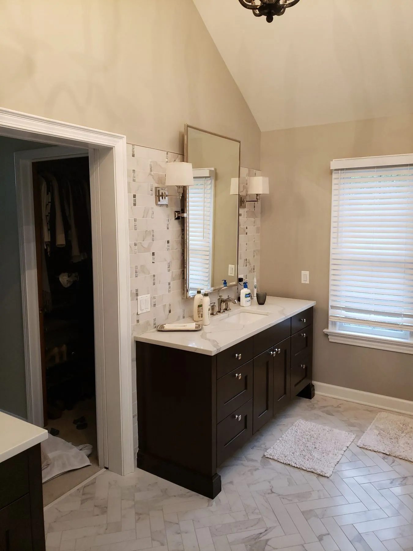 Dark vanity with a tall mirror and sconces