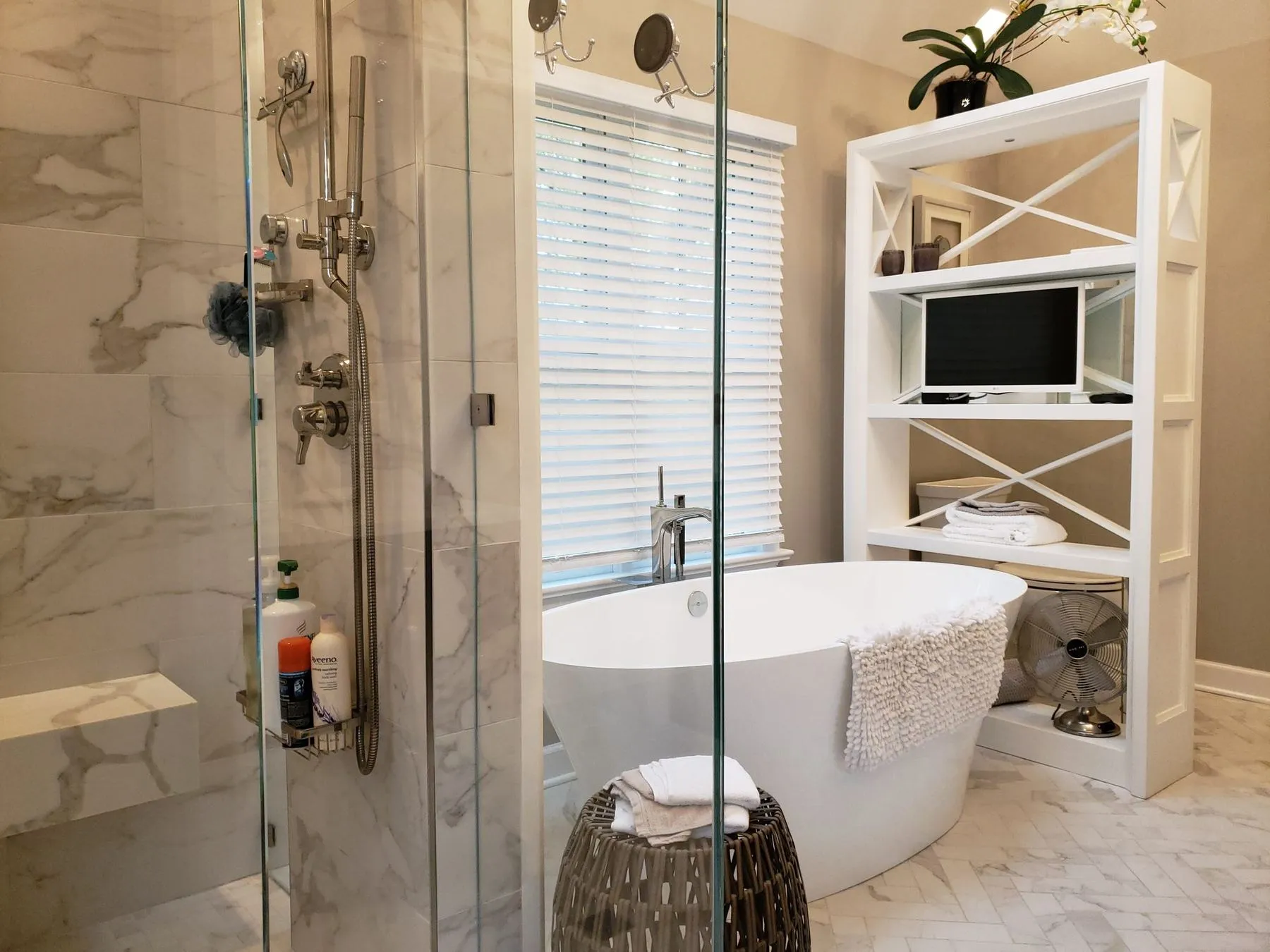 Shower fixtures and tub beside open shelving