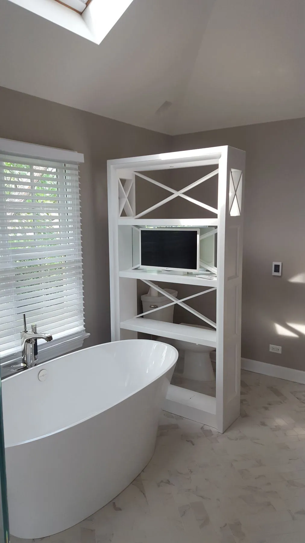 Freestanding tub under a skylight with open shelving
