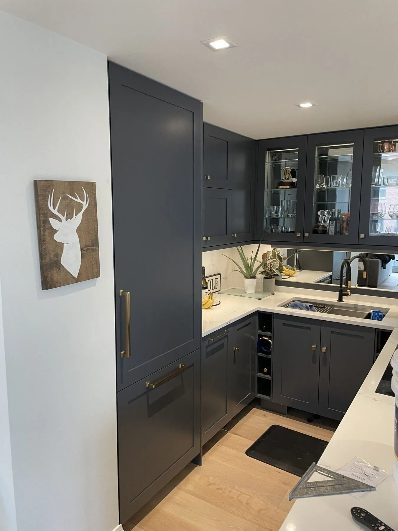 Navy kitchen seen from the side with a paneled refrigerator