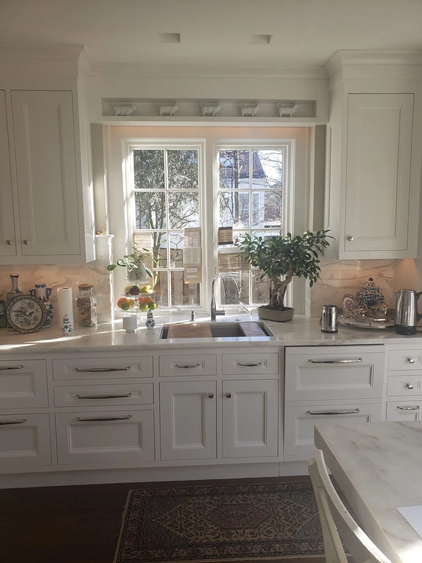 Sink under a window with white cabinets on both sides