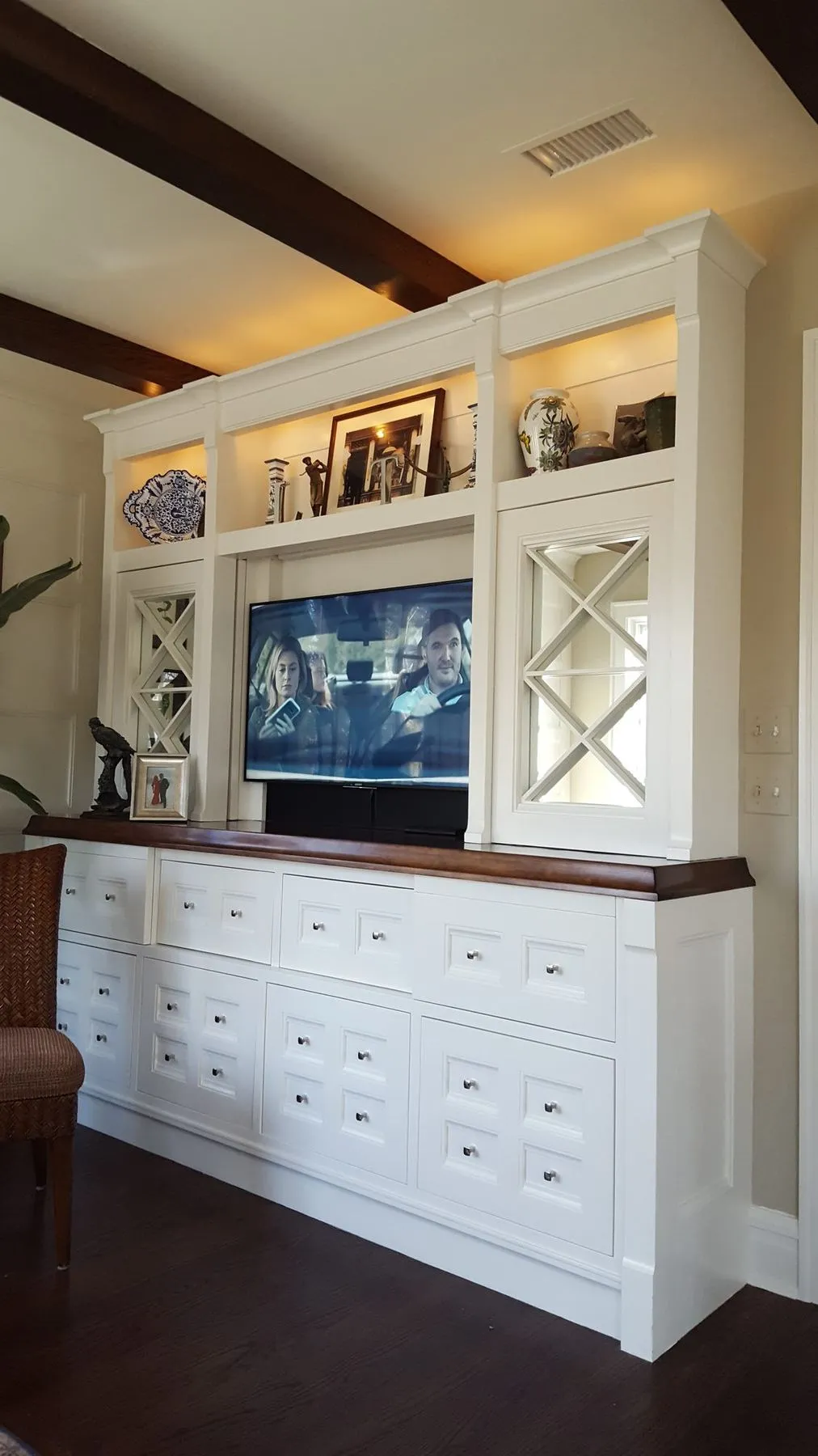 Built-in media cabinet with lit shelves and many drawers