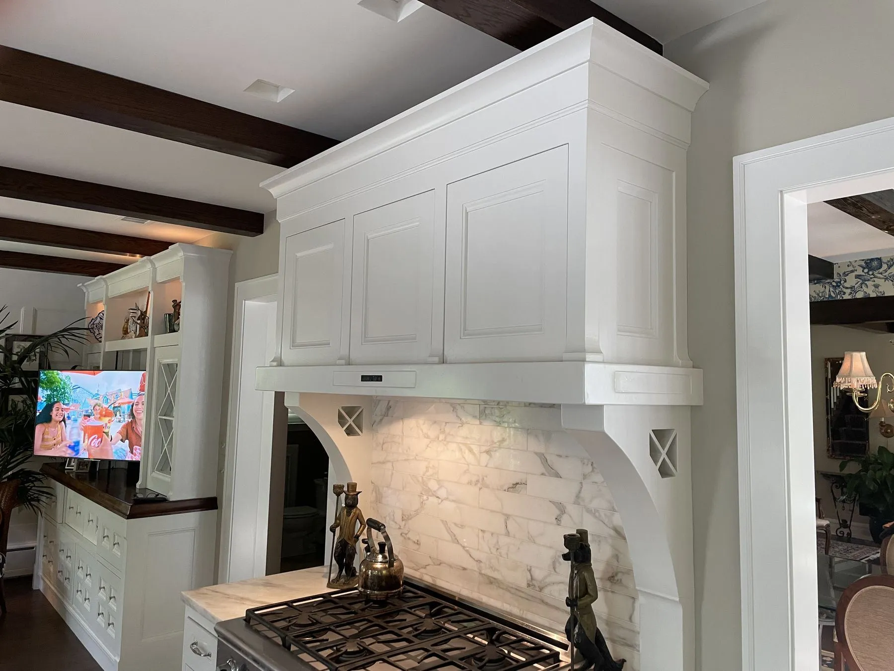 Custom range hood with a marble backsplash and corbels