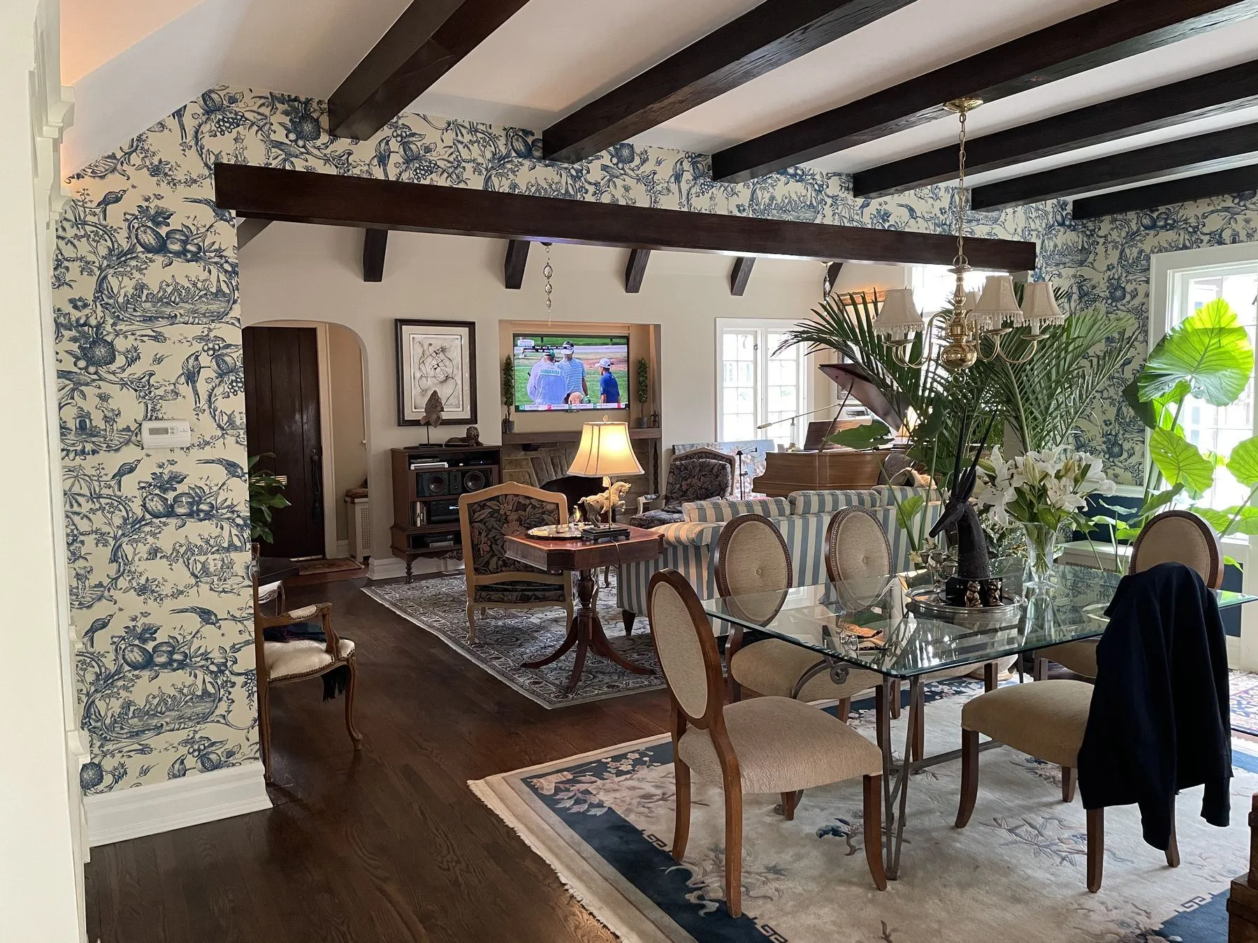 Dining room with toile wallpaper and dark ceiling beams