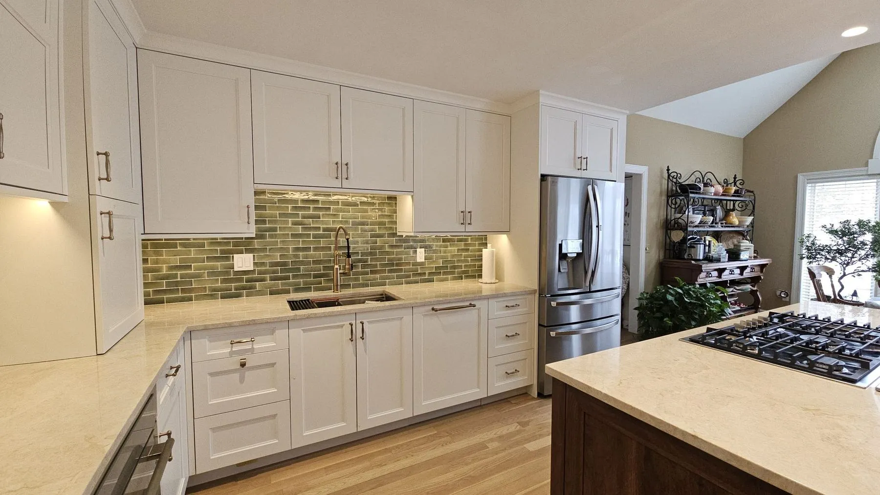 Sink wall with green tile, open corner shelves, and a gas cooktop