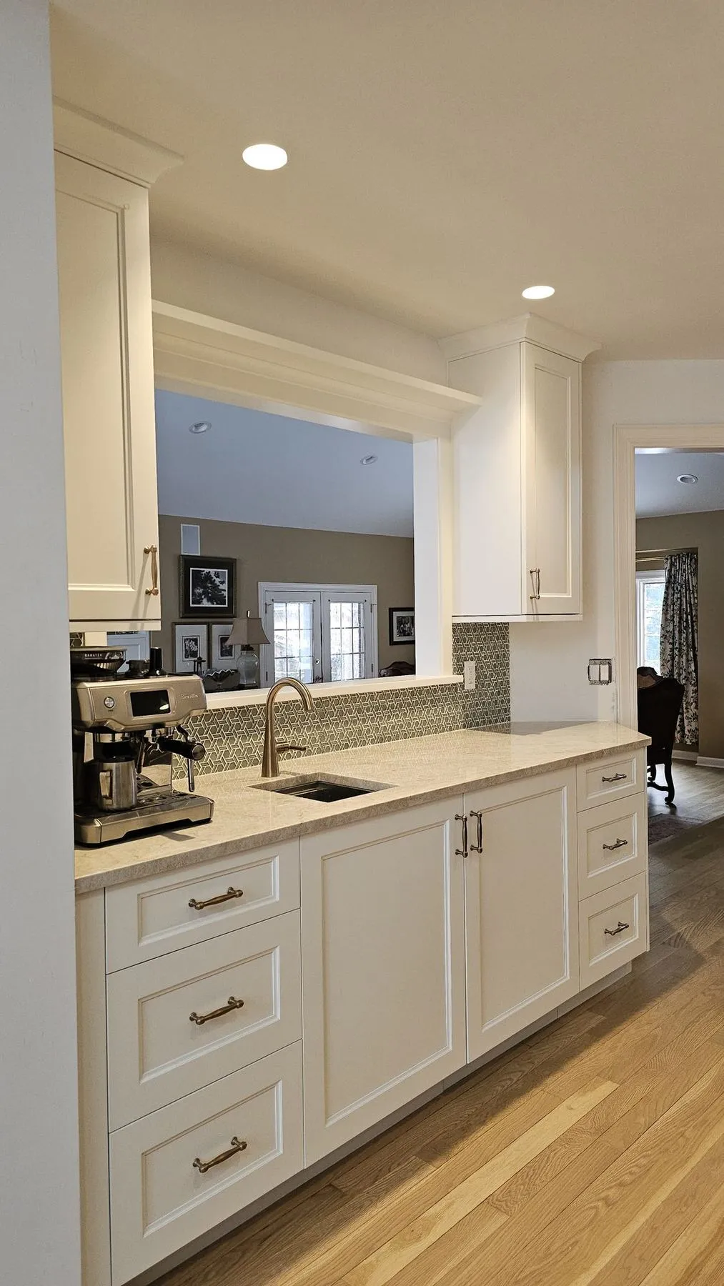 White cabinets and a coffee station beside an interior window